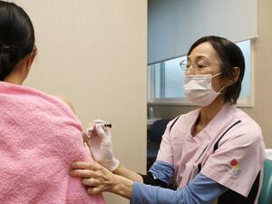 HPVワクチンを接種する女性。定期接種の対象外になったが、キャッチアップ接種の制度を活用した=新潟市中央区のロイヤルハートクリニック