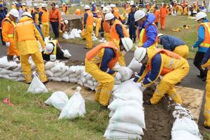 半円状に土のうを積む「月の輪工」を実践する水防訓練の参加者＝２４日、新潟市南区