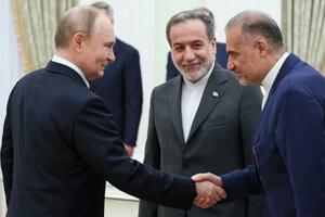 23日、ロシア・モスクワで会談する前のプーチン大統領(左)とイランのアラグチ外相(中央)(AP=共同)