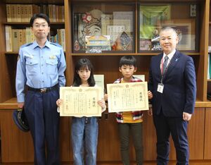 交通安全の標語が入賞し感謝状を手にした川口結大さん(右から2人目)と大湊陽月さん(右から3人目)=五泉市論瀬