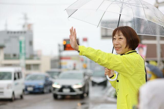 通勤者にお礼のあいさつをする菊田真紀子さん＝１０月２８日午前７時３０分過ぎ、三条市荒町２