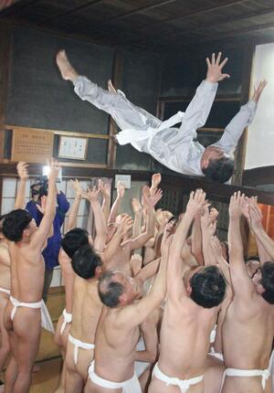 男性を勢いよく放り上げた「裸胴上げ」＝１７日夜、糸魚川市藤崎