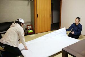 「さどマッチボックス」を利用し、民宿敷島荘で働く女性(左)。「市公式のサイトだから安心して使える」と語る=佐渡市稲鯨