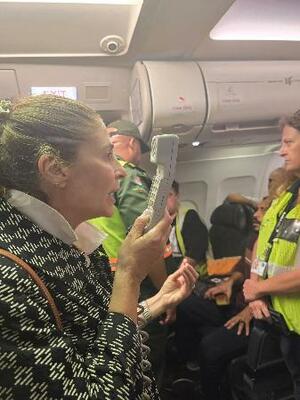 　南アフリカ・ヨハネスブルクに着陸した航空機内で話す南ア駐在のパレスチナ大使（左）＝１３日（在南ア・パレスチナ大使館のフェイスブックから、ロイター＝共同）