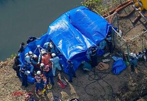 作業員4人がマンホールの中に転落した現場で救助活動に当たる消防隊員ら=2日午後3時19分、埼玉県行田市(共同通信社ヘリから)