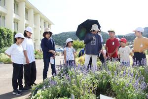 児童が地域住民らに花壇を案内した桂小のオープンガーデン=長岡市桂町