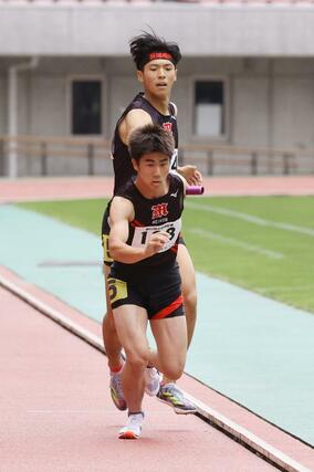 男子4×400メートルリレー決勝 優勝した新潟明訓。3走森飛遥(写真奥)がアンカー星山海燕にバトンを渡す=デンカビッグスワン