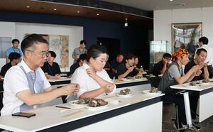野菜の餌で身がやわらかくなったサザエの試食会=佐渡市両津夷