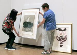 三条美術協会展を前に、新設された版画部門の作品の展示準備をする会員=17日、三条市荒町2