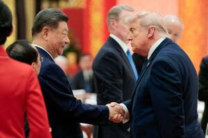 　夕食会で握手するトランプ米大統領（右）と中国の習近平国家主席＝１４日、北京の人民大会堂（ロイター＝共同）