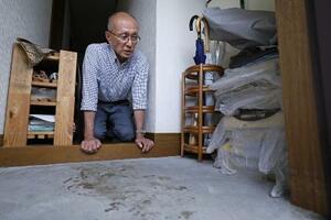 高羽奈美子さんが殺害されたアパートの玄関に残る犯人のものとみられる血痕を見つめ、取材に応じる夫悟さん=昨年11月、名古屋市