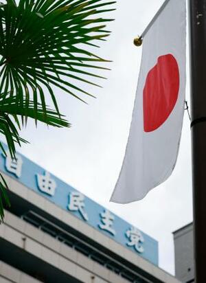 自民党本部前ではためく日本国旗=9日、東京・永田町