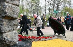 　２６日、ベラルーシ・ミンスクの追悼碑に花を手向ける「チェルノブイリ功労者の会」の人々（共同）