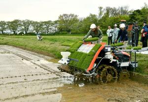 岩塚製菓と県農業大学校が行った多収栽培実証の田植え=4月28日、新潟市西蒲区