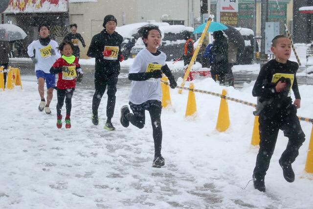 雪が降る中、懸命にゴールを目指すランナー＝１月１日、三条市