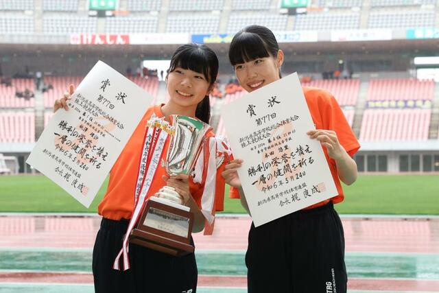 女子200メートル決勝 200メートルを制した秋澤理沙(左・東京学館)。チームメートで4位に入った本田悠里と笑顔で写真撮影に応じる=デンカビッグスワン