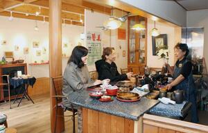 ギャラリーやまぼうしの店内で、作家らと話すオーナーの馬場悦子さん(右)=新潟市秋葉区あおば通1