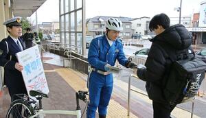 通学中の高校生らに自転車の青切符制度を周知する「サイクルポリス」ら＝２月、燕市のＪＲ吉田駅前