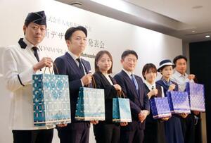 大丸松坂屋百貨店の新しいショッピングバッグを持つ従業員ら=17日午前、東京都千代田区