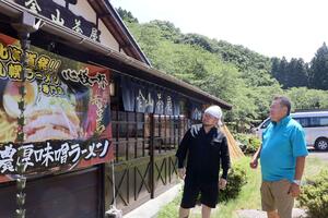 佐渡金山ラーメン茶屋の前で語り合う大桃一浩さん(右)と谷川澤翔さん。来夏は北海道展の開催を構想している=佐渡市相川奈良町