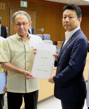 本田太郎防衛副大臣(右)に要請書を手渡す沖縄県の玉城デニー知事=22日午後、防衛省