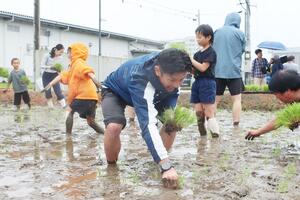 子どもたちと一緒に田植えをするラグビー元日本代表キャプテンの広瀬俊朗さん=魚沼市十日町