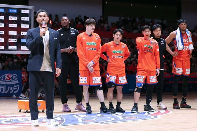 試合に勝利し、ほっとした表情でブースターにあいさつする佐藤優樹アシスタントコーチ（左）＝アオーレ長岡