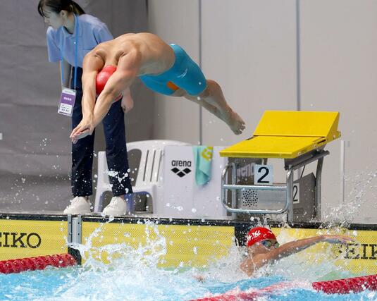 競泳・成年男子２００メートルリレー決勝　第３泳者の頓所拓海からアンカーの石崎慶祐につなぐ＝佐賀市（長岡支社・芳本卓也）