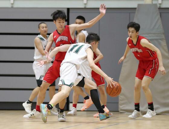 男子決勝トーナメント１回戦　実践学園－本丸　第３クオーター、粘り強く守る本丸の選手ら＝アオーレ長岡