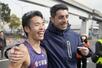 男子20キロ競歩で世界新記録を樹立し、東京五輪金メダリストのマッシモ・スタノ(右)に祝福される山西利和=25年2月、六甲アイランド甲南大周辺コース