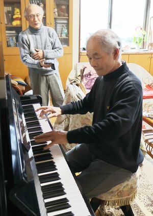 乙女の祈りを弾く藤木則男さんと、見守る山田武雄さん=柏崎市