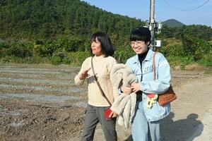 韓国・長興の自宅近くを歩くアナリ・エチョンさん(左)と長女、高永仁さん=2025年11月(共同)