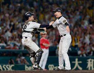 リーグ優勝を決め、抱き合う阪神の岩崎(右)と坂本のバッテリー=甲子園