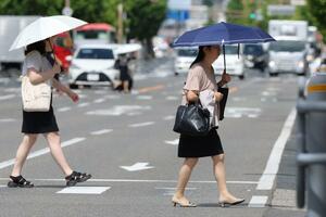 強い日差しの中、日傘を使うなどして外を歩く人たち=14日、新潟市中央区