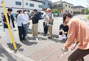 フィールドワークで道路の道幅を測る新潟工科大の学生=柏崎市