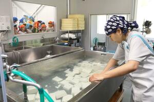 リニューアルオープンした工場で「三川とうふ」を作るスタッフ＝阿賀町岩谷
