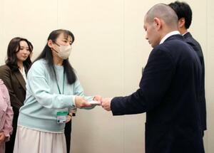 「包括的性教育」の学校現場への導入を求め、文科省の担当者(右)に要望書を手渡す市民グループの佐藤晴美代表=30日午後、国会