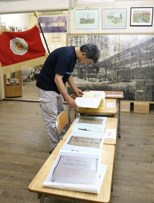 加茂西小学校の足跡を伝える資料が並ぶ展示会場=加茂市加茂