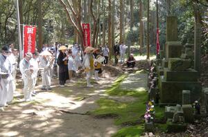 無宿人の墓前で読経する供養祭の参加者＝佐渡市相川地区