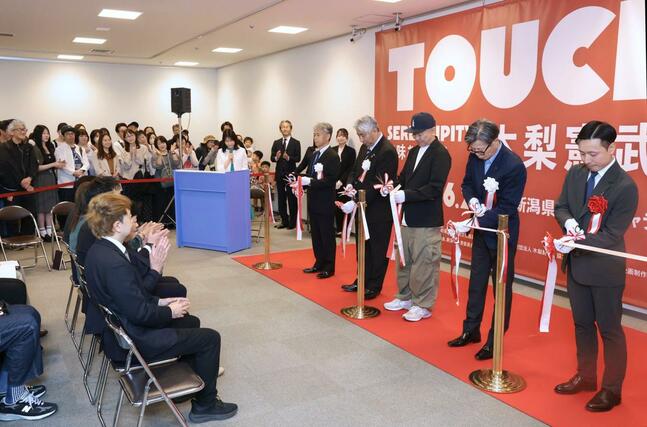 オープニングセレモニーでテープカットをする木梨憲武さん（右から３人目）＝２３日、新潟市中央区の県民会館