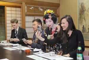 行形亭で古町芸妓と記念撮影する訪日客ら=11月、新潟市中央区