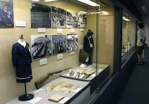 「武運長久」と書かれた日章旗や当時の生活用品、回覧文書などが並ぶ企画展=佐渡市八幡