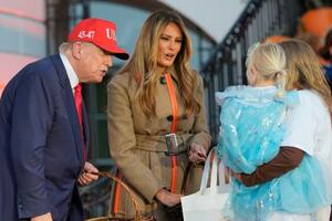 30日、米ワシントンのホワイトハウスで、ハロウィーンイベントに参加したトランプ大統領(左)と妻メラニアさん(AP=共同)