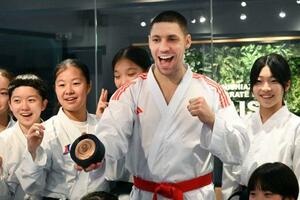 返還された銅メダルを手に、笑顔で写真に納まるスタニスラフ・ホルナさん=5日、東京都港区