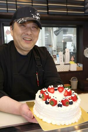 デコレーションケーキを手に語る佐藤徹夫さん=新潟市西区のル・タン・メルヴェイユ