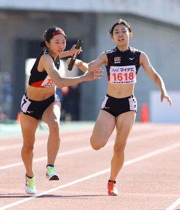 女子１６００メートルリレータイム決勝　１７位の新潟明訓　２走の石黒果乃（右）から３走の中俣日乃（左）へバトンをつなぐ＝７月２９日、広島市