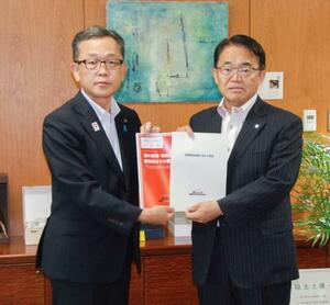 要請書を手に写真撮影に応じる愛知県の大村秀章知事(右)と経産省の竹内真二政務官=6日、経産省