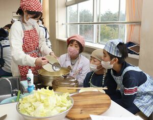 郷土料理研究家の井部真理さんに教わりながらさかきん発酵鍋を作る児童たち=上越市下荒浜の八千浦小