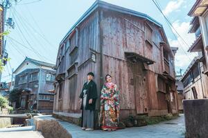 歴史を感じられる町並みで結婚写真を撮るカップル=佐渡市宿根木(プロムサド提供)