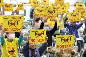 　集会で「ＮＯ！！オスプレイ」と書かれたプラカードを掲げる参加者＝５日午後、佐賀市